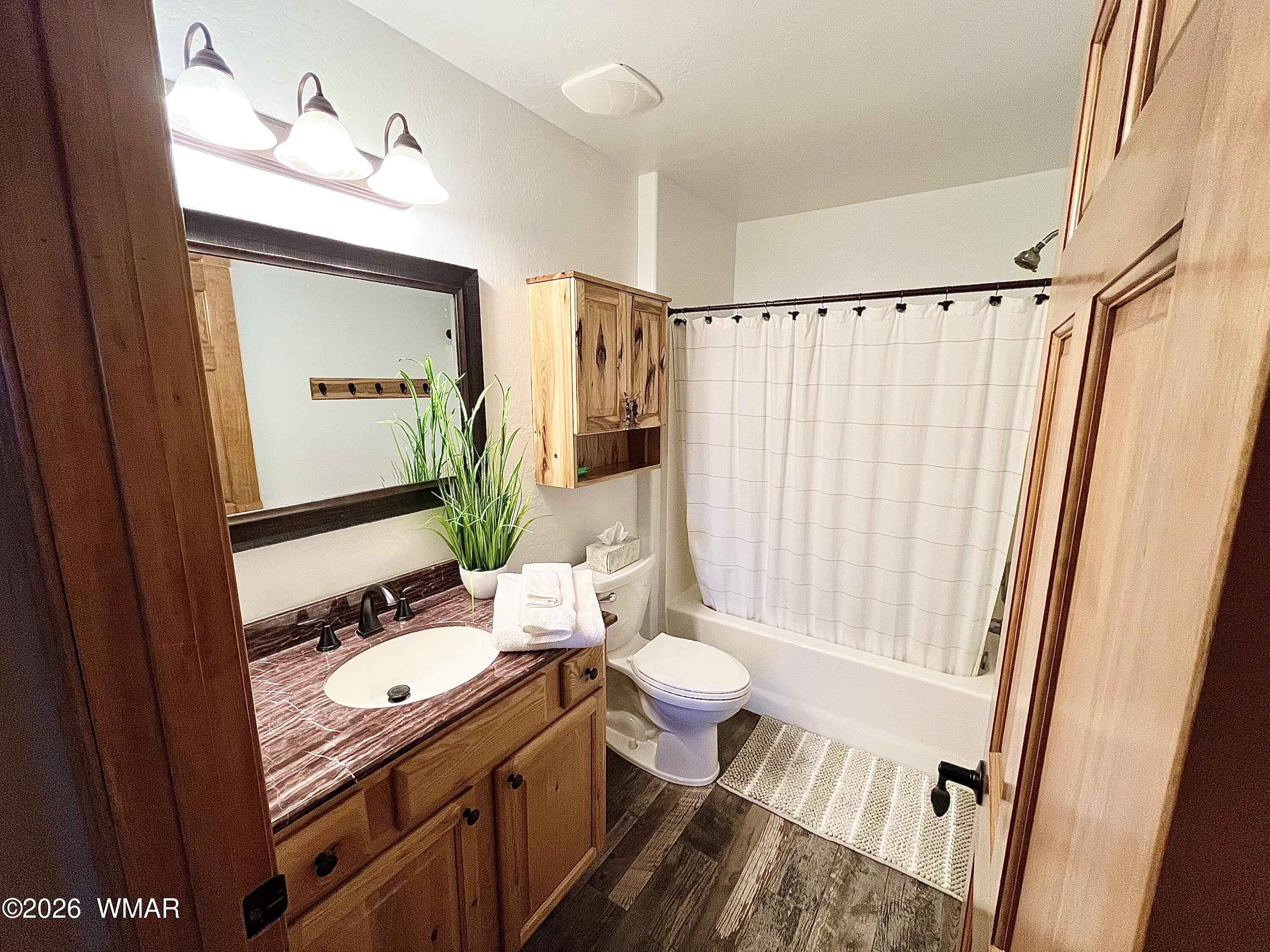 2334 Buffalo Loop Overgaard, AZ 85933 - Photo 10 of 25 a bathroom with a granite countertop sink toilet a mirror a vanity and shower