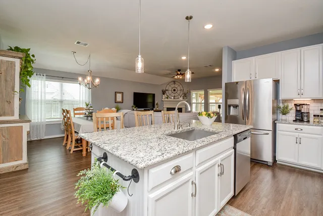a view of a dining room with furniture a chandelier and wooden floor
