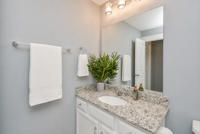a white toilet sitting next to a white cabinet