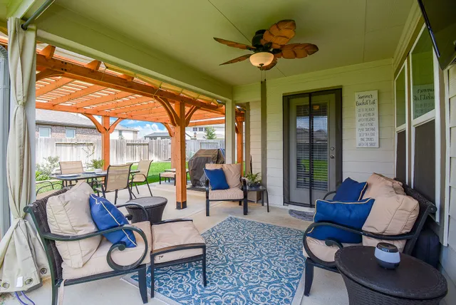 a view of a patio with table and chairs potted plants and a palm tree