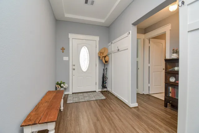 a view of a hallway with wooden floor and a living room
