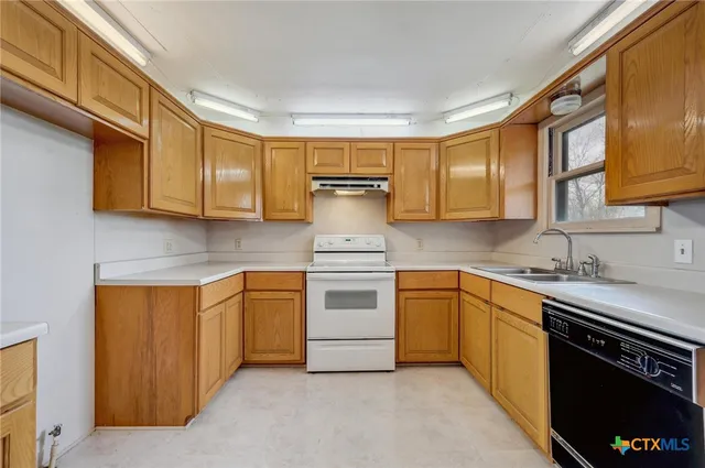a kitchen with stainless steel appliances granite countertop a stove sink and cabinets