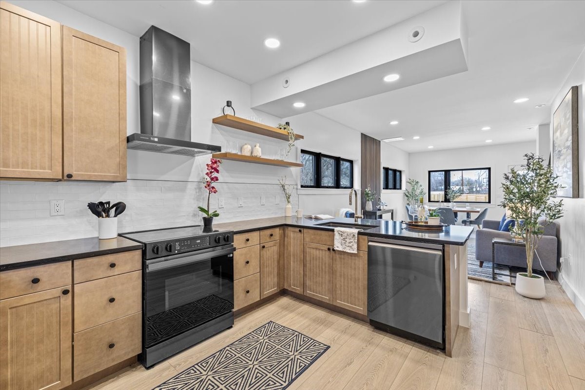2406 West 10th Street, Unit A Austin, TX 78703 - Photo 4 of 13 a kitchen with stainless steel appliances granite countertop a stove top oven a sink dishwasher and cabinets with wooden floor