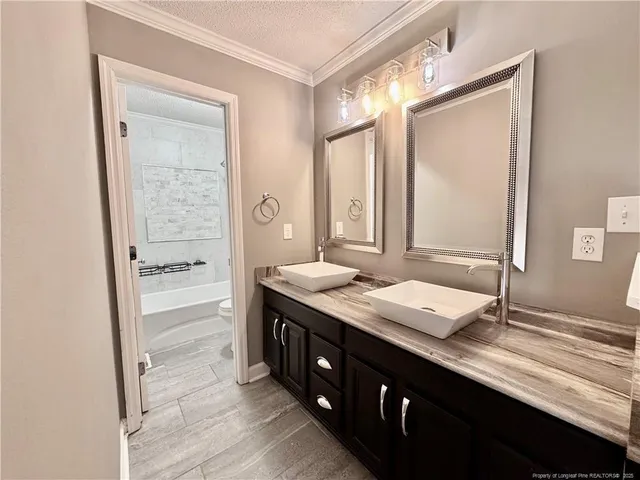 a bathroom with a granite countertop sink a large mirror and a shower