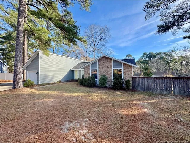 a front view of house with yard and trees