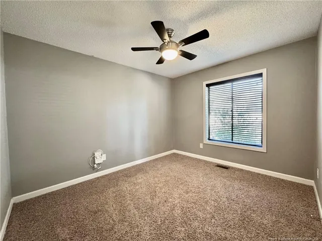 a view of a livingroom with a ceiling fan and window