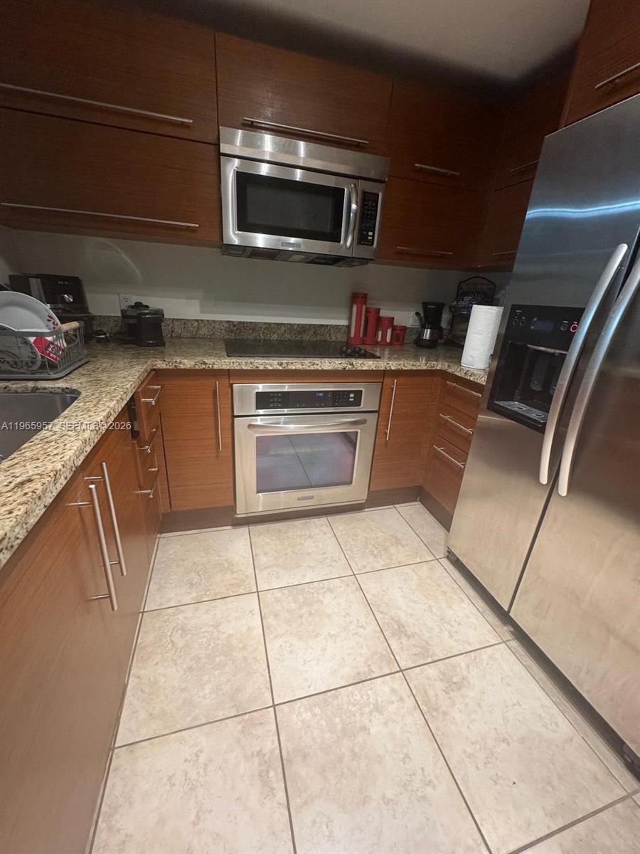 2681 North Flamingo Road, Unit 2302S Sunrise, FL 33323 - Photo 13 of 25 a kitchen with stainless steel appliances granite countertop a sink and cabinets
