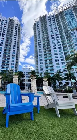 a view of a chairs and table in back yard of a building