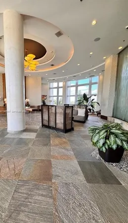 a lobby with furniture and a potted plant