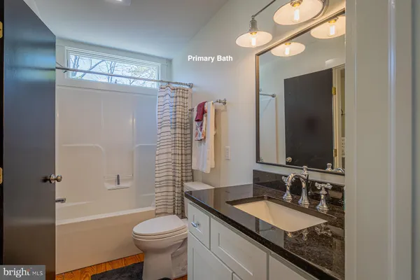 a bathroom with a granite countertop sink toilet and shower