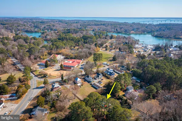 an aerial view of residential houses with outdoor space and trees