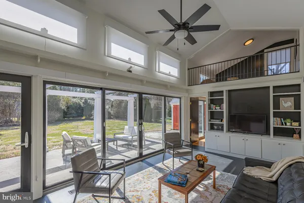 a living room with furniture floor to ceiling window and a flat screen tv