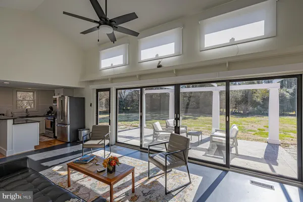 a living room with furniture tv and a floor to ceiling window
