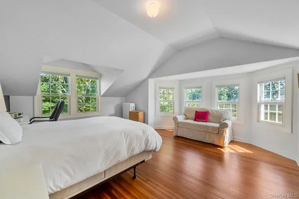a bed sitting in a spacious bedroom next to a window