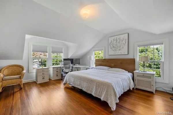 a bedroom with a bed and a wooden floor