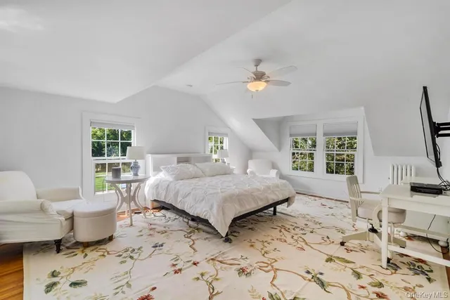 a spacious bedroom with a bed couch and a window