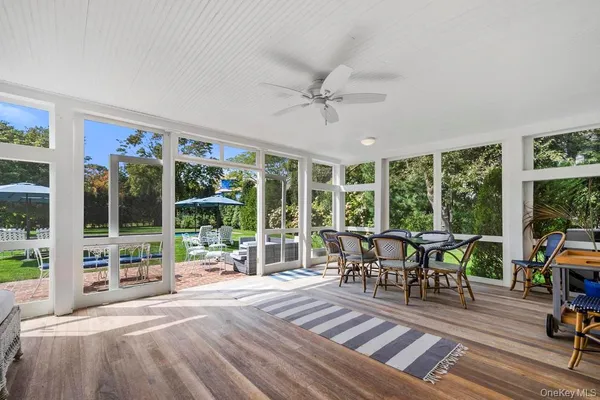 a view of a dining room with furniture large windows and wooden floor