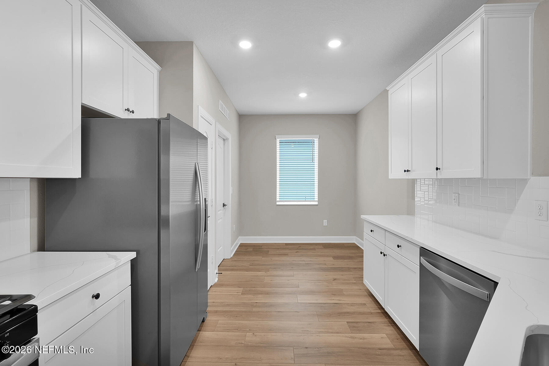 2420 Pemrose Loop Middleburg, FL 32068 - Photo 8 of 25 a kitchen with white cabinets and black appliances