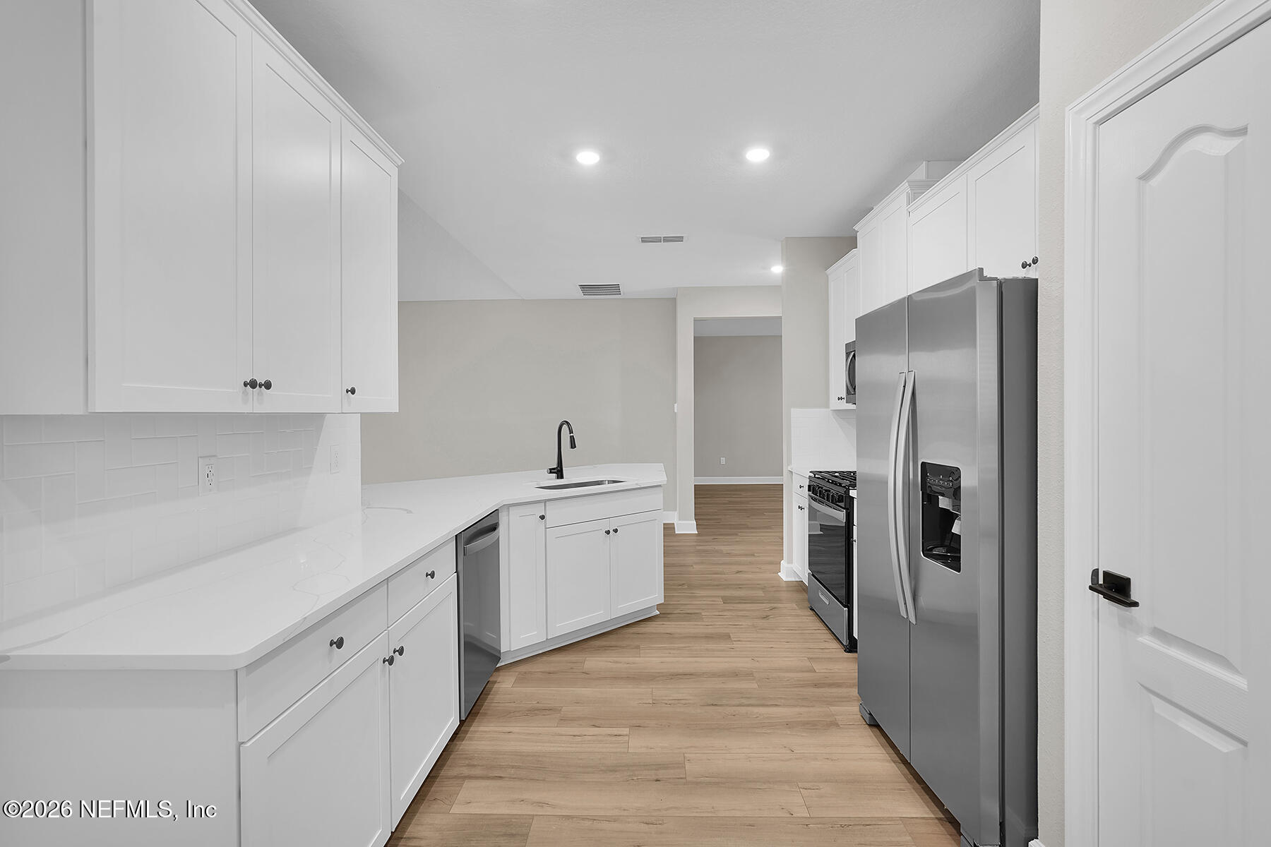 2420 Pemrose Loop Middleburg, FL 32068 - Photo 9 of 25 a large white kitchen with a sink and refrigerator