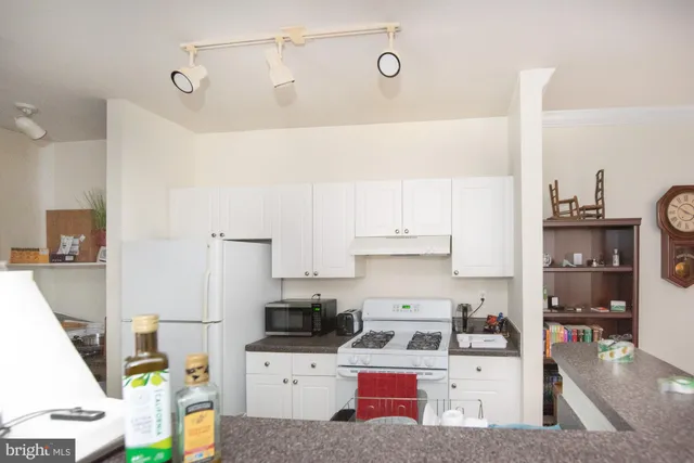 a kitchen with stainless steel appliances kitchen island granite countertop a sink and cabinets