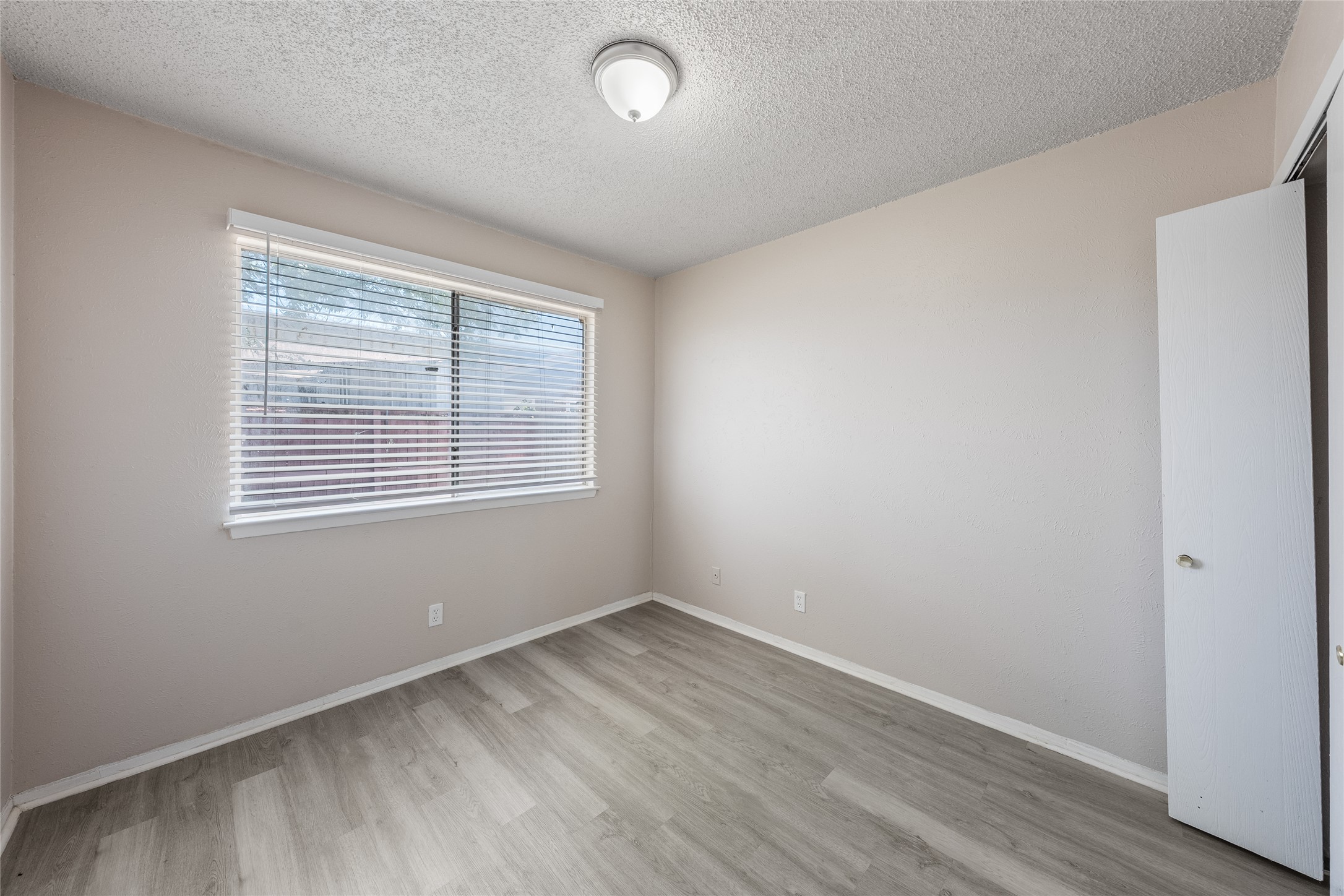 1111 West Rundberg Lane Austin, TX 78758 - Photo 7 of 16 A well-lit bedroom with fresh flooring offers a versatile space for rest or productivity.