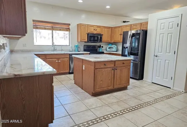a kitchen with stainless steel appliances granite countertop a refrigerator and a sink