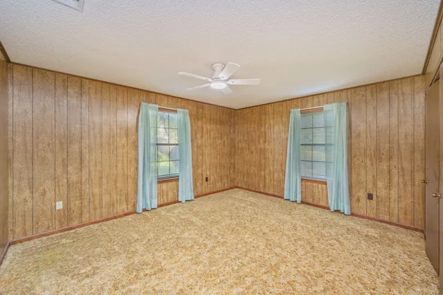 a bedroom with a large bed and a chandelier fan
