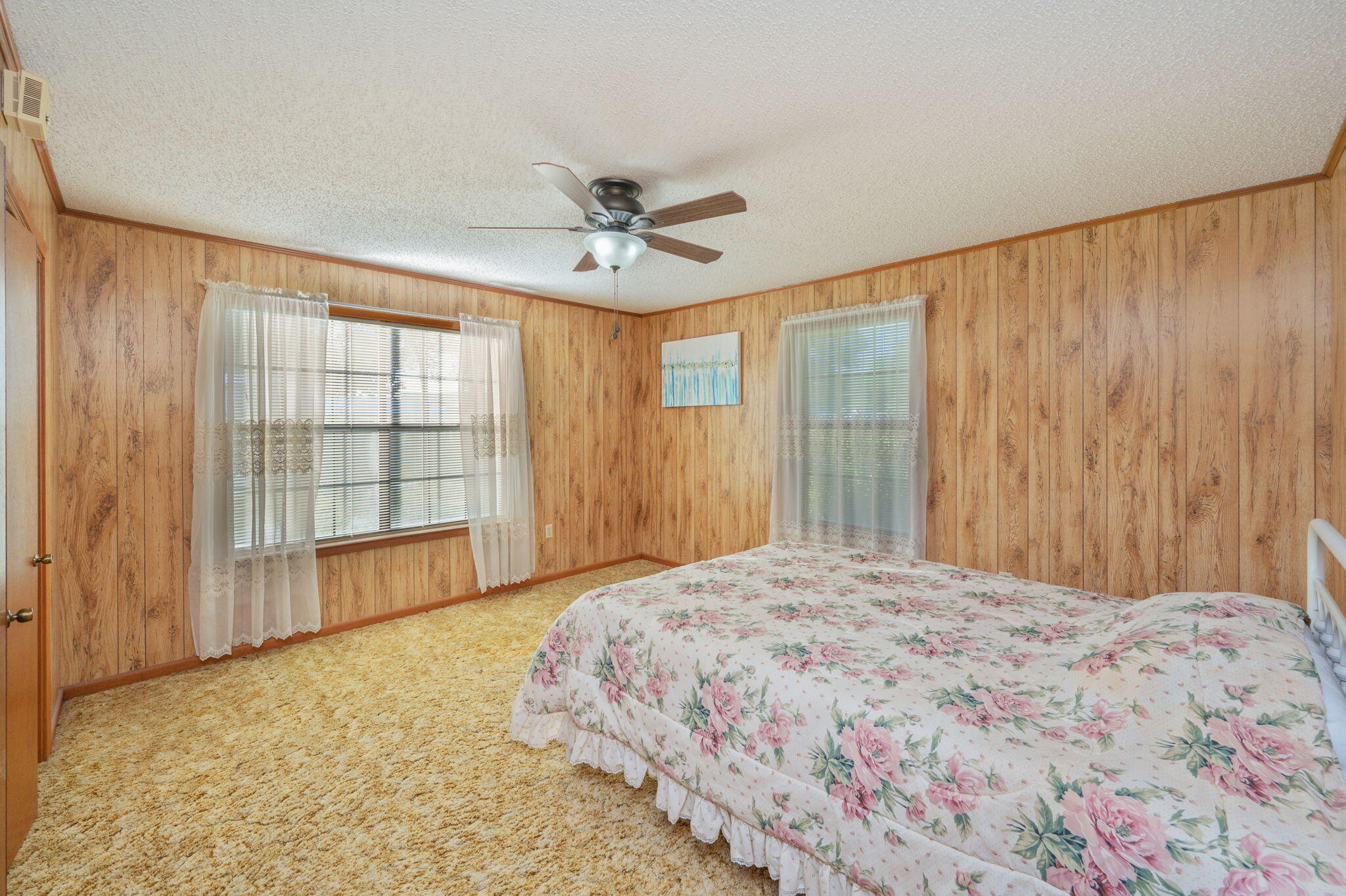 1260 East Chestnut Avenue Crestview, FL 32539 - Photo 40 of 61 a bedroom with a large bed and a chandelier