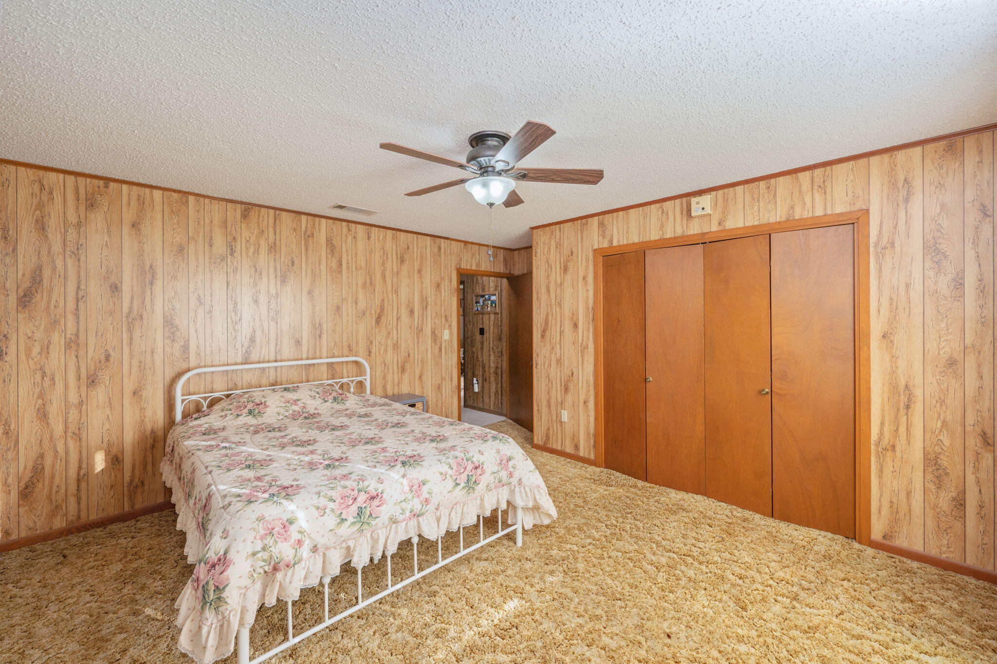 1260 East Chestnut Avenue Crestview, FL 32539 - Photo 41 of 61 a bedroom with a large bed and a chandelier fan