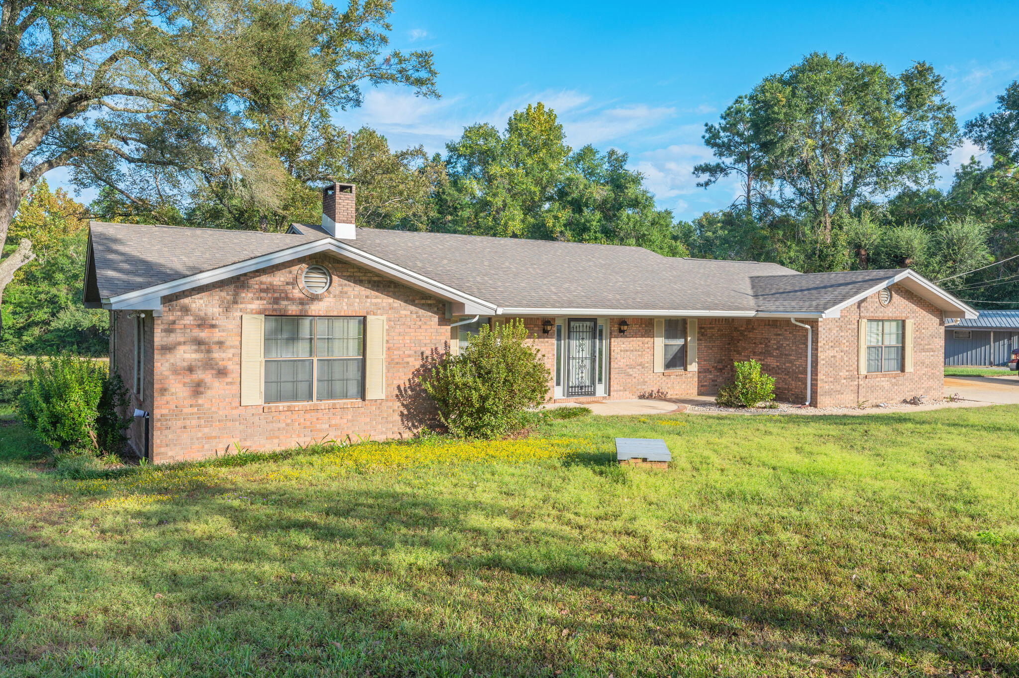 1260 East Chestnut Avenue Crestview, FL 32539 - Photo 9 of 61 a front view of a house with a yard and trees