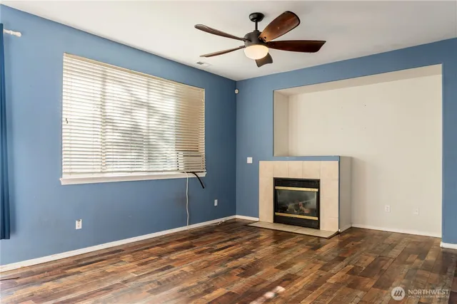 a view of an empty room with a window and fireplace