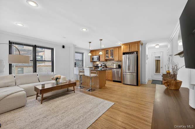 a living room with furniture kitchen view and a large window