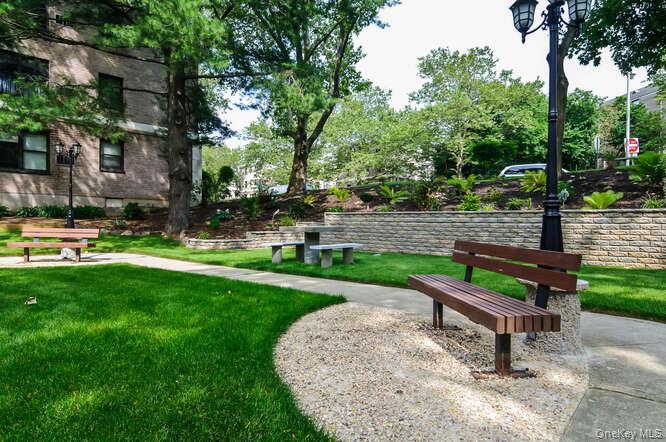46 Terrace Circle, Unit 1B Great Neck, NY 11021 - Photo 15 of 16 a park view with a bench and trees