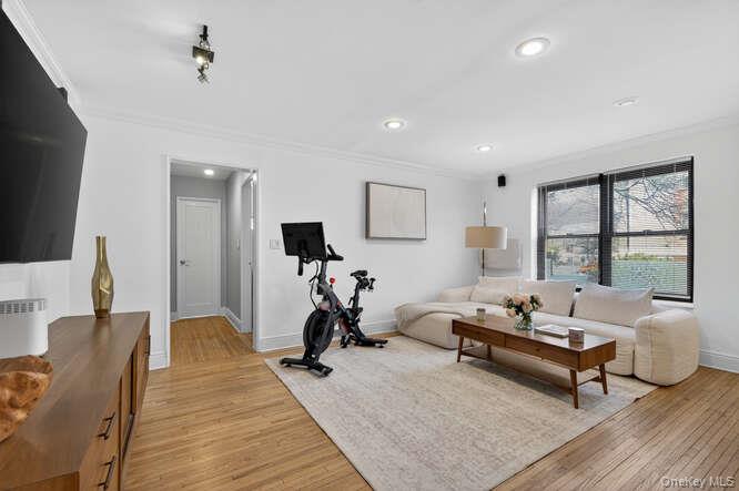 46 Terrace Circle, Unit 1B Great Neck, NY 11021 - Photo 3 of 16 a living room with furniture a flat screen tv and a table