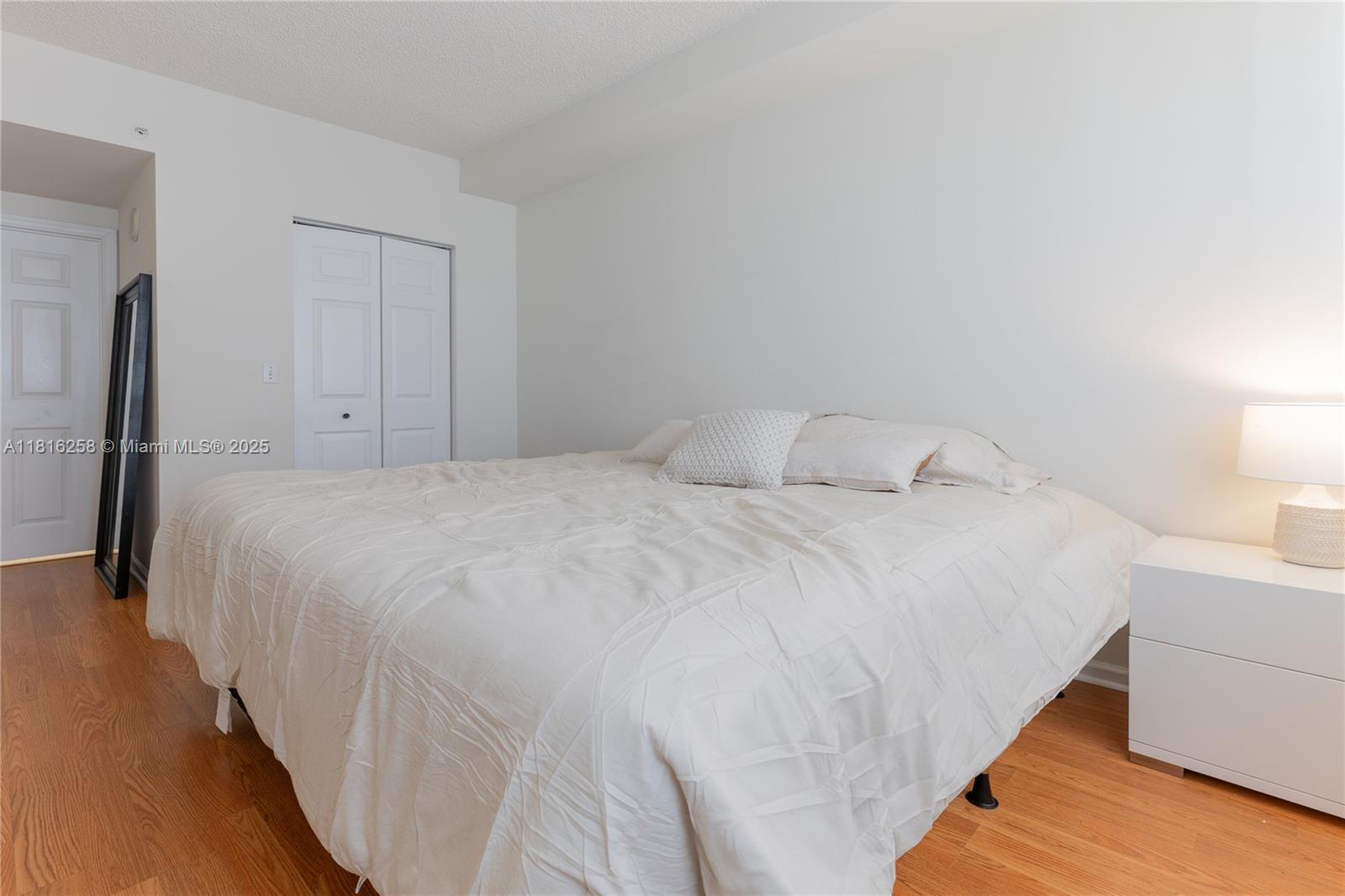 17100 North Bay Road, Unit PH1912 Sunny Isles Beach, FL 33160 - Photo 17 of 39 a large bed sitting in a bedroom and a lamp