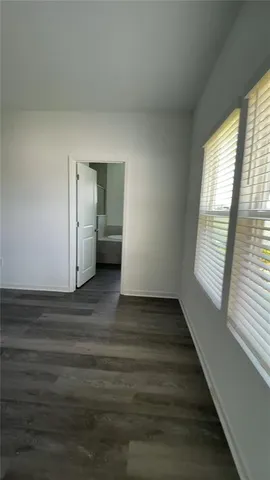 a view of empty room with window and wooden floor