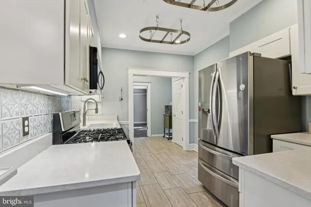a kitchen with stainless steel appliances a refrigerator and a stove top oven