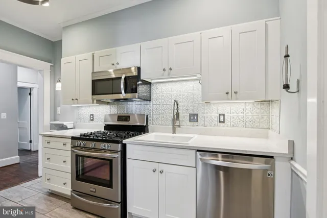 a kitchen with cabinets stainless steel appliances and a sink