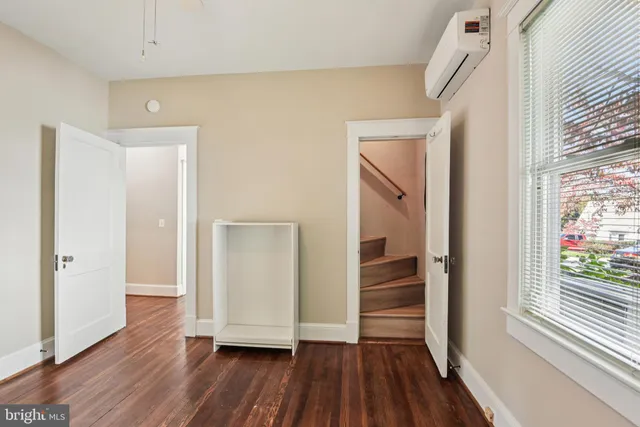 a view of a hallway with wooden floor and closet