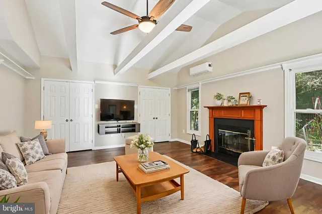 a living room with furniture a flat screen tv and a fireplace