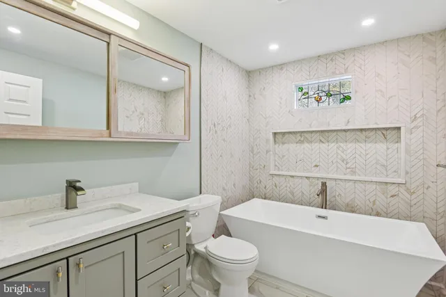 a bathroom with a sink a toilet and a mirror