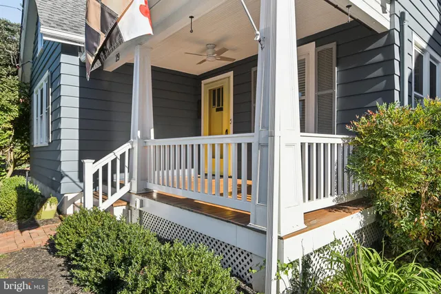 a view of a house with porch and wooden fence