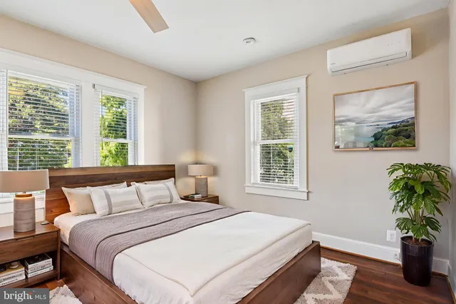 a bedroom with a bed and a potted plant next to a window