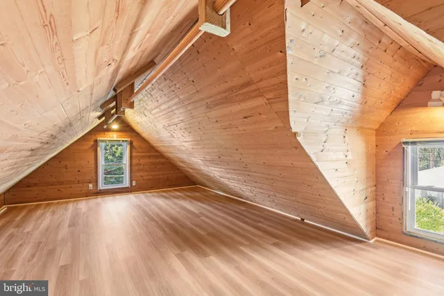 a view of a hallway with wooden floor and stairs