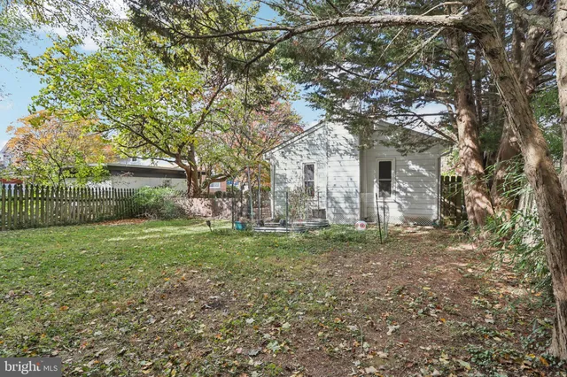 a view of a yard in front of a house with a large tree