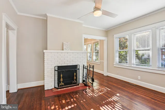 a living room with a fireplace and wooden floor