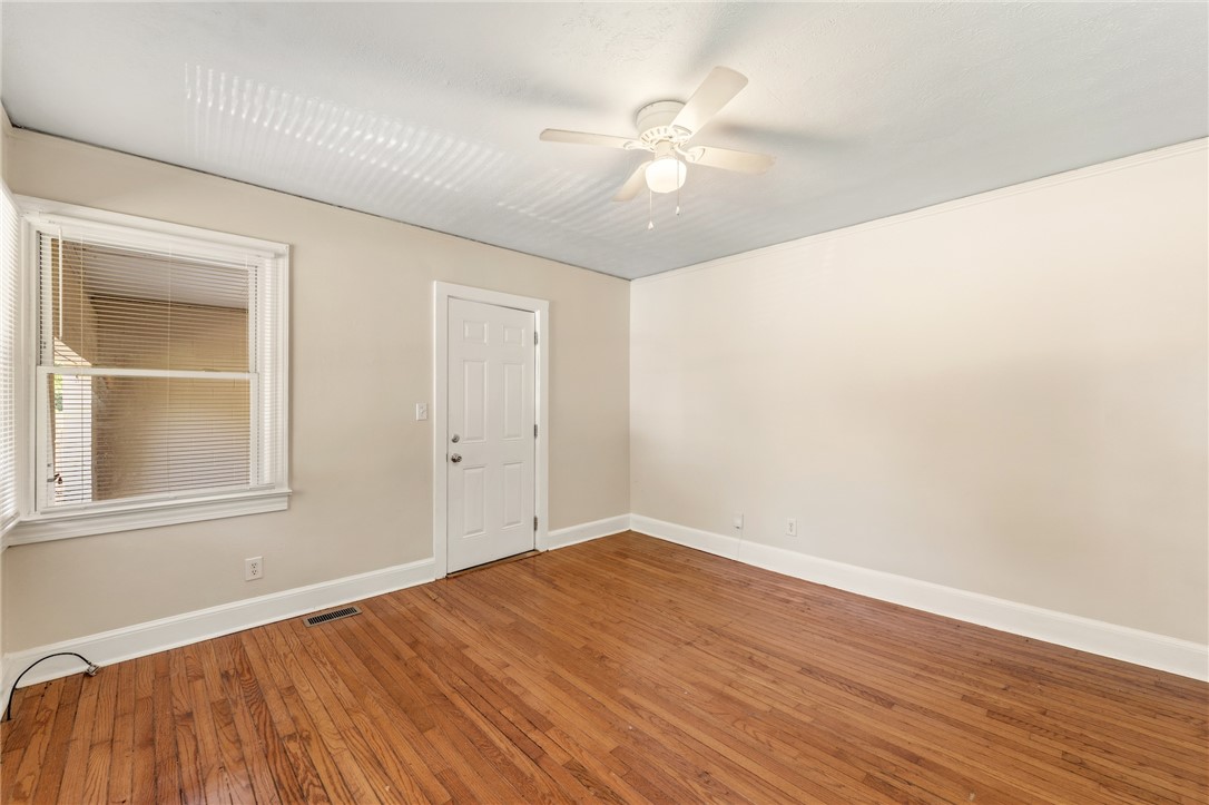 606 Perry Road Greenville, SC 29609 - Photo 5 of 22 Rich hardwood flooring and classic wood-framed windows anchor this versatile, light-filled space.