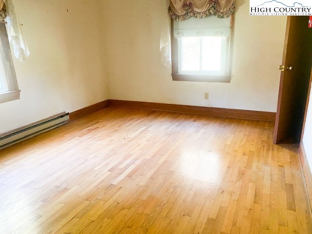 453 Smith Acres Road Ennice, NC 28623 - Photo 20 of 30 a view of an empty room with wooden floor and a window