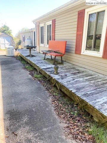 a view of an empty room with window and hardwood floor