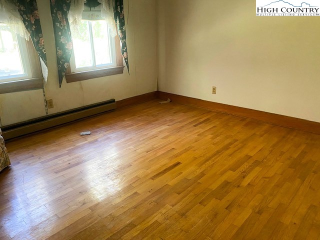 453 Smith Acres Road Ennice, NC 28623 - Photo 9 of 30 an empty room with wooden floor and windows